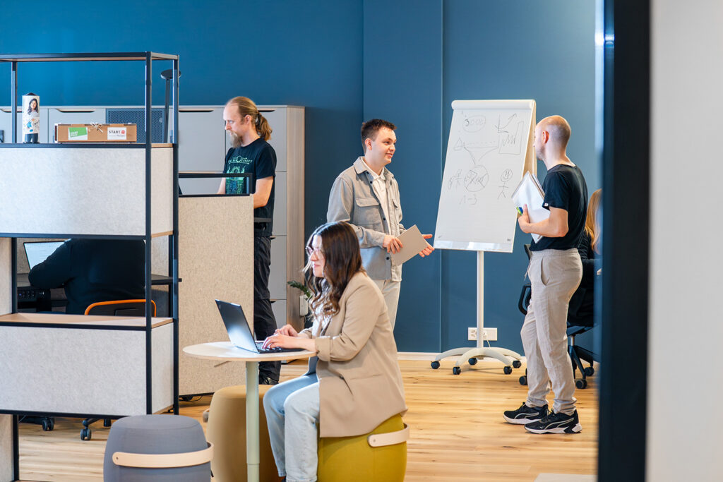 Vier Personen arbeiten und diskutieren im modernen Coworking Space des I+D Campus