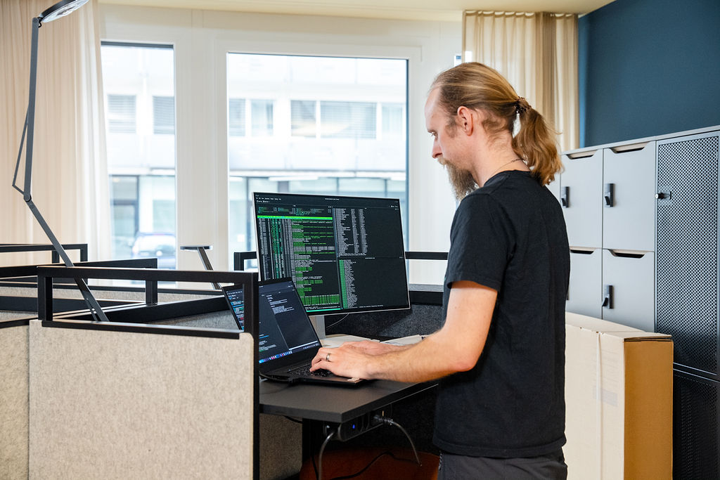 Person arbeitet am Steharbeitsplatz im Coworking Space des I+D Campus