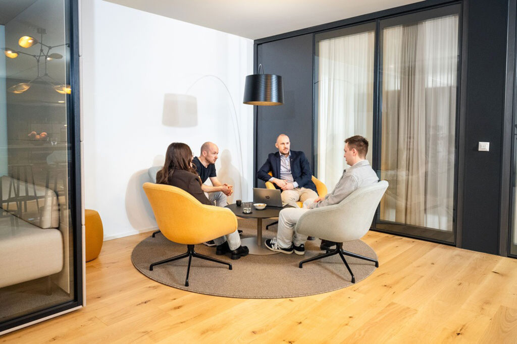 Vier Personen im Gespräch in der Lounge des I+D Campus